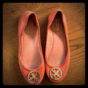 ALDO orange flats with a gold medallion